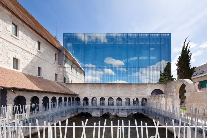 A semi-transparent and reflective façade allows the building to exploit its surrounding heritage.photo © Opus 5