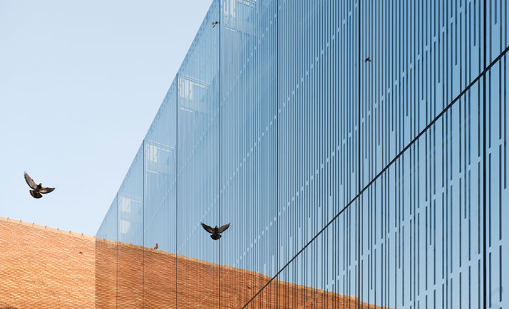 The glass panels intersect the old building, exposing the surroundings through its mirrored qualities.photo © Opus 5