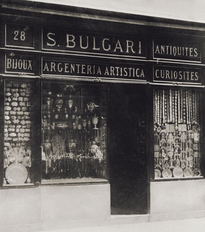 Front of Bulgari's second Roman shop at 28 Via dei Condotti, photographed around 1900. The sign reads: ''S.Bulgari - Argenteria Artistica, Antiquités, Curiosités, Bijoux''. The windows, crammed with  great variety of silver objects, also display numerous belt buckles - typical ornaments of Sotirio's production at that time. Photo © Bulgari Archives.