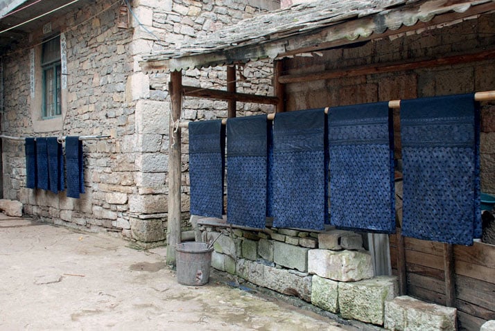 Skirt panels drying under the awning of a house in the Bouyi village of Shitou Zhai, China.‘Indigo: The Colour That Changed the World’, photo © Catherine Legrand / Thames &amp; Hudson.