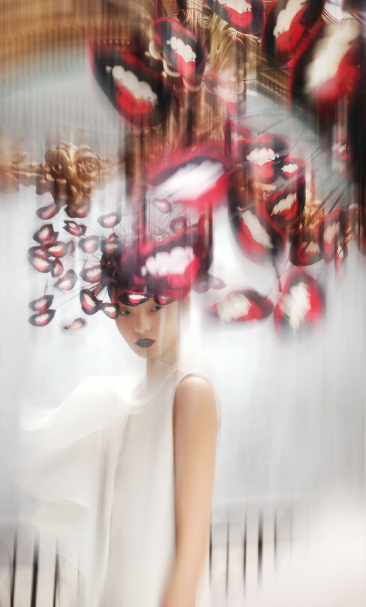 Hat: Philip Treacy, S/S 2003. Cut out mouths pop art hat, paper, silk and  wire. Dress: Chalayan, S/S 1999. Cream folded pleat dress, silk. Model:  Xiao Wen Ju at IMG. photo © Nick Knight.