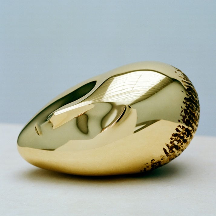 Constantin Brancusi, La Muse Endormie, 1923-2010, polished bronze, 7 3/8 x 10 1/4 x 6 1/8 inches, edition of 8. Photography by Francois Halard/© Artists Rights Society (ARS) New York/ADAGP, Paris. / Courtesy of the Brancusi Estate and Paul Kasmin Gallery.{Sleeping Muse II (1923), whose first version attracted the most attention in 1913, resulted in his first requests from collectors for bronze editions. It features also an abstracted face of a woman, like Mademoiselle Pogany II’s serpentine figure beckons the viewer with her subdued look. Sleeping Muse II transforms the viewer into a voyeur watching over the sleeping woman with delicate suggestions of a nose, large oval-shaped closed eyes, and a half-open mouth.}