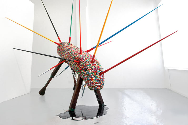 Fantich &amp; Young, Mascot, 2012. Sculpture dimentions: (H) 310cm x (W) 380cm x (L) 415cm. Materials: Vaulting Horse, Military Medals Ribbons, Junior Sport Javelins, Crude Oil. Photo © Fantich &amp; Young.