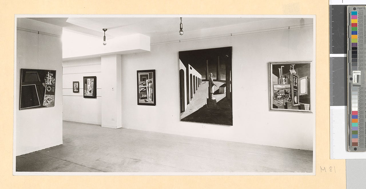 Installation view of “Giorgio De Chirico, Exhibition of Early Paintings”, Pierre Matisse Gallery, New York, 1940. Among the exhibited works: La nostalgie de l'ingénieur (1916) - For the work © Giorgio De Chirico by SIAE 2018 Pierre Matisse Gallery New York, N.Y. archives, 1903-1990, Box 100The Morgan Library &amp; Museum. MA 5020. Gift of the Pierre Matisse Foundation, 1997. 3. 205567v_0534 Black-and-white editorial.