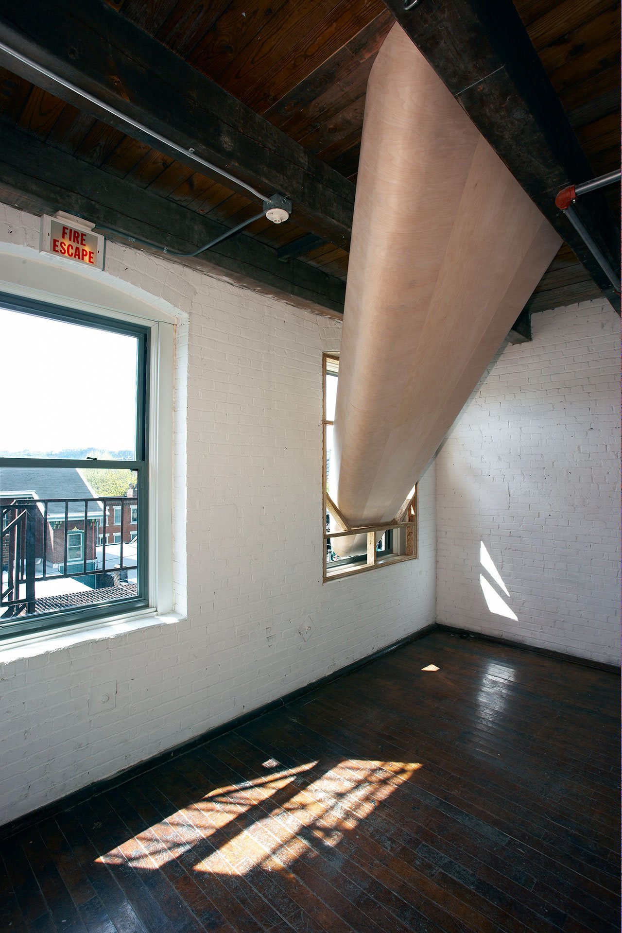 SARAH OPPENHEIMER, 610-3365, 2018.Views from the third and fourth floor.Plywood and existing architecture.Fourth floor opening dimensions: 84″ × 16″.Total dimensions variable.Installation view: Mattress Factory, Pittsburgh, USA, 2008.