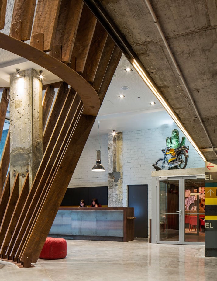 Generator BARCELONA. Hostel reception in timber and blackened steel, exposed concrete columns and vintage 1973 Derbi Spanish motorcycle and collectable and rare Gufram rubber cactus. Photo © Nikolas Koenig.