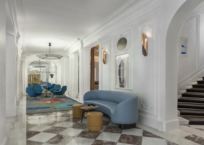 The entrance hall // Carrare marble floor. Abstract carpet: designed by Jean-Michel Alberola. Blue armchairs: designed by Rodolfo Dordoni and made by Minotti Blue leather bench: designed by FrancÌ§ois Champsaur. Ceramic coffee table, French-made circa 1950. Photo © Hôtel Vernet, Paris, Champs-Élysées.