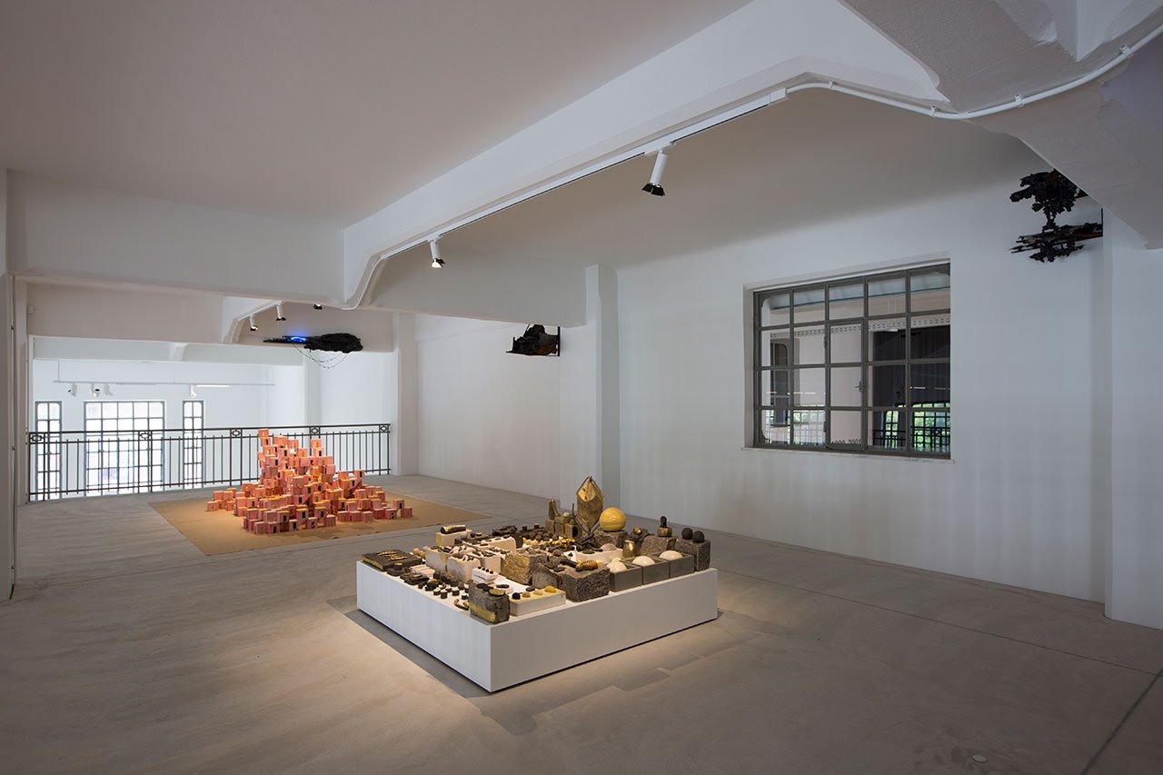 Installation View Portals, Hellenic Parliament + NEON at the former Public Tobacco Factory, Photography © Natalia Tsoukala. Courtesy NEON
Featured (front to back):
Erika Verzutti, Cemetery of Yellows, 2019. Clay, concrete, bronze, stones. 28 × 150 × 150 cm. Courtesy of Alison Jacques, London.
Nikos Alexiou, Fear, 2003. Watercolor on paper. Dimensions variable Private Collection, Athens.
Alexandros Tzannis, Interference, Noise and Message (The Parasite Series), 2020-2021. Iron, rust, magnets, neodymium magnets, glass, ceramic, bronze, neon light, iron pyrite, lepidolite, azurite. Dimensions variable. Courtesy the artist Commissioned by NEON.