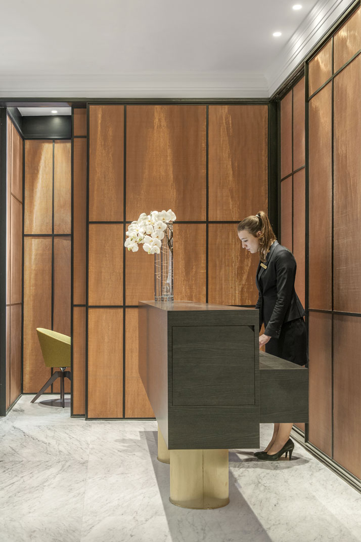 Reception desk in black oak resting on two brass pedestals, designed by François Champsaur and made by Gendre. Screen in brass mesh designed by François Champsaur and made by Gendre. Armchairs made by PHS. Photo © Hôtel Vernet, Paris, Champs-Élysées.