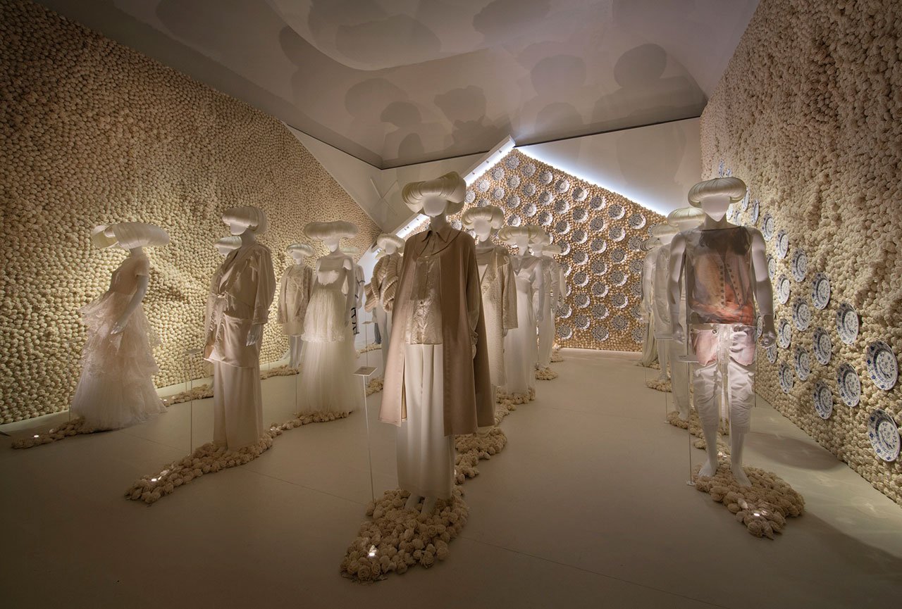 Utopian Bodies, installation view of Solidarity gallery. A room entirely in white, with custom-made wigs by Perry Patraszewski and clothes by Minna Palmqvist, Gudrun Sjödén, Ida Sjöstedt and Sandra Backlund. Photo: Mattias Lindbäck