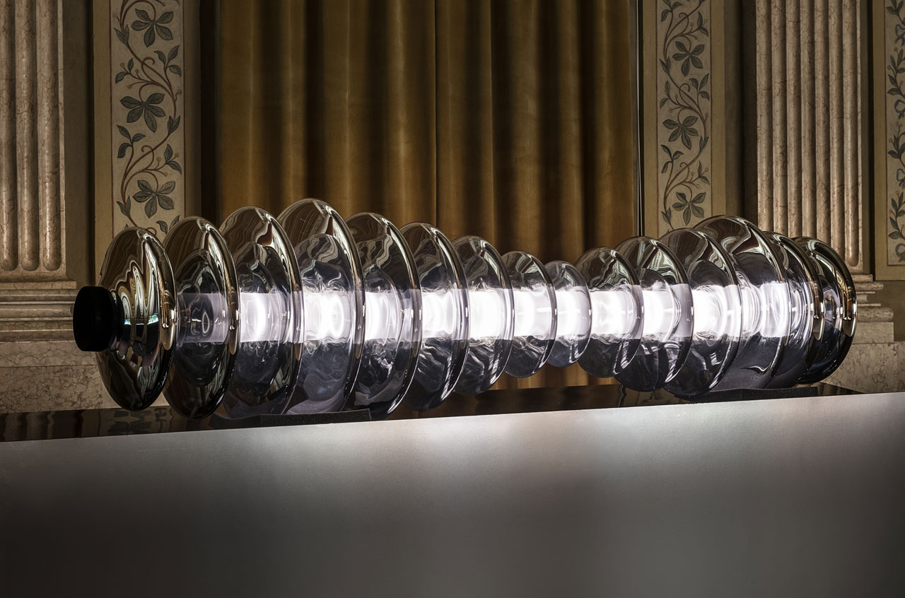WonderGlass 在 Istituto dei Ciechi 举办的 KOSMOS 展览现场图。 图为：studiopluz 的 Echo，“一个发光的雕塑让人想起祖先的旋律，由一系列玻璃圆盘组成，将玻璃与感官融合在一起，产生刺激的声音景观，让人联想到来自黑洞的引力波”。摄影：Leonardo Duggento。