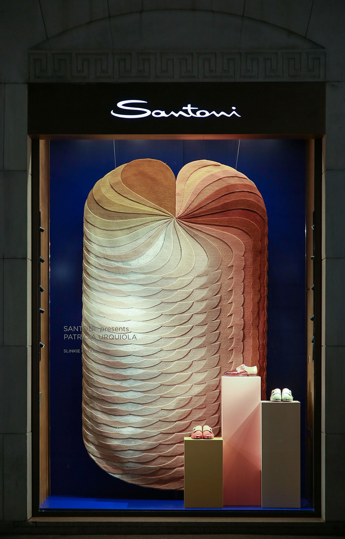 Patricia Urquiola 为 cc-tapis 设计的 Slinkie 地毯新系列在 Santoni 精品店的橱窗中展出，限量版双和尚鞋与地毯以相同的调色板生产。